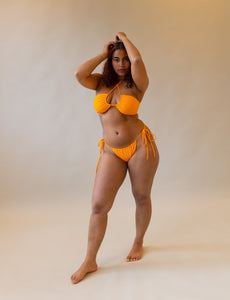 ruching bikini bottom in orange on model